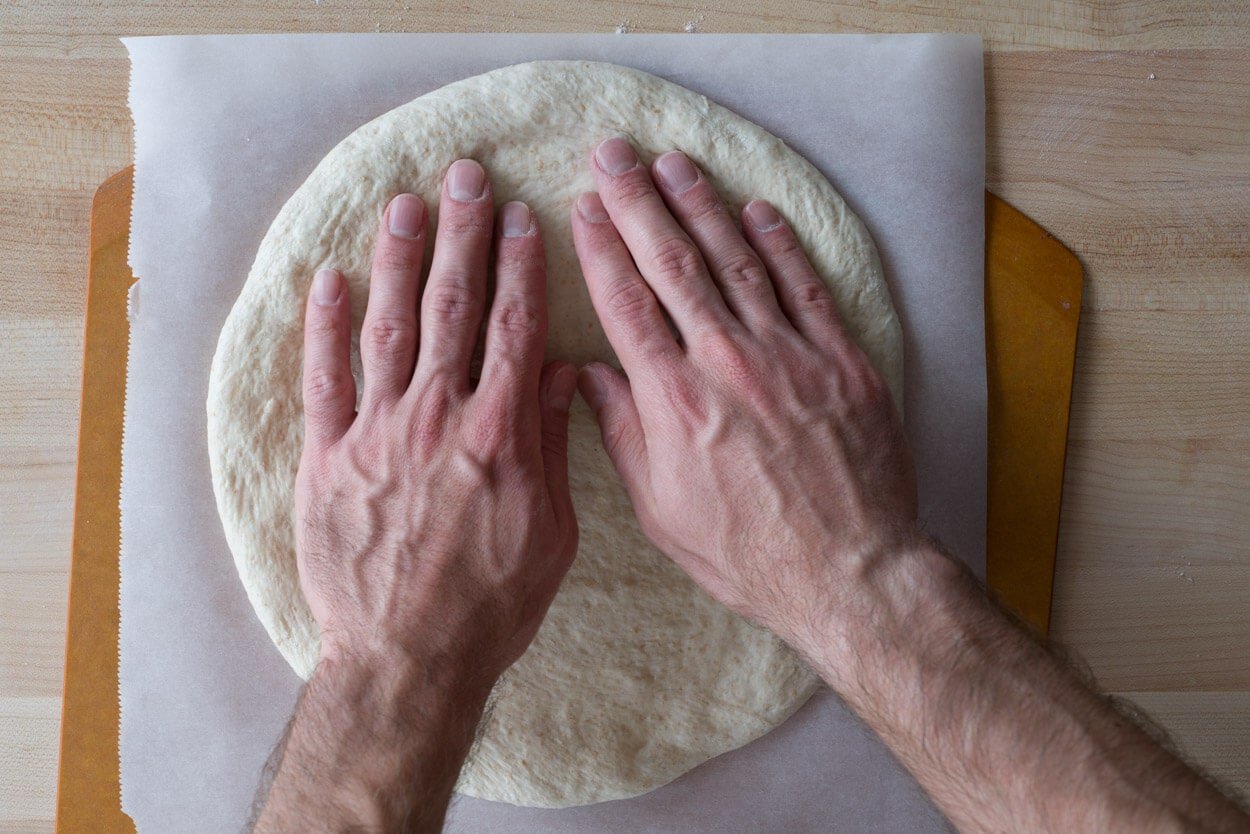 Shaping out sourdough pizza dough into a 12" circle. 