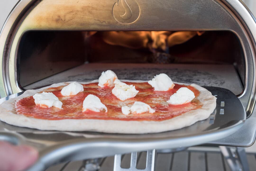 Loading pizza dough into the Roccbox