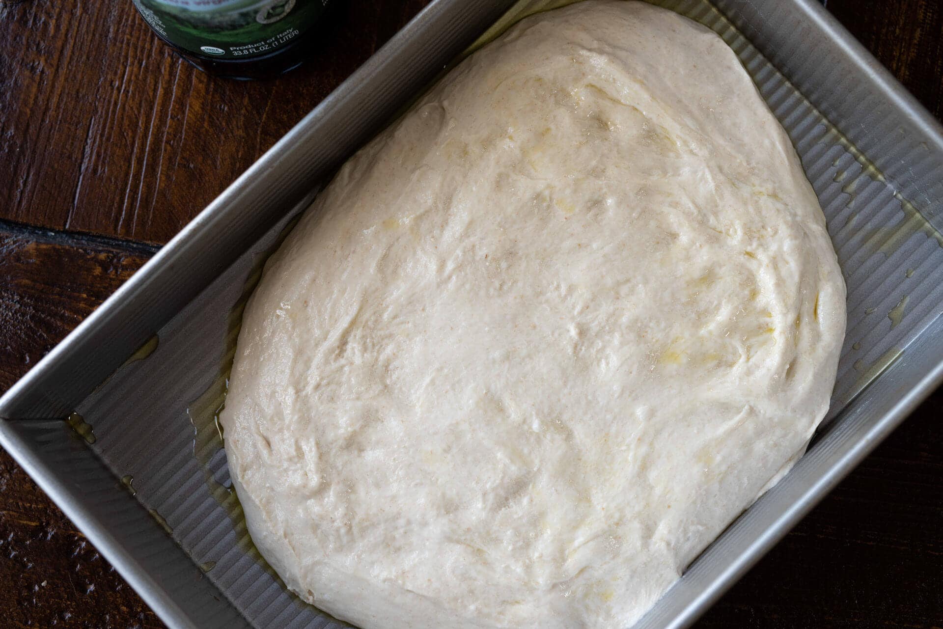 Spreading focaccia dough in pan
