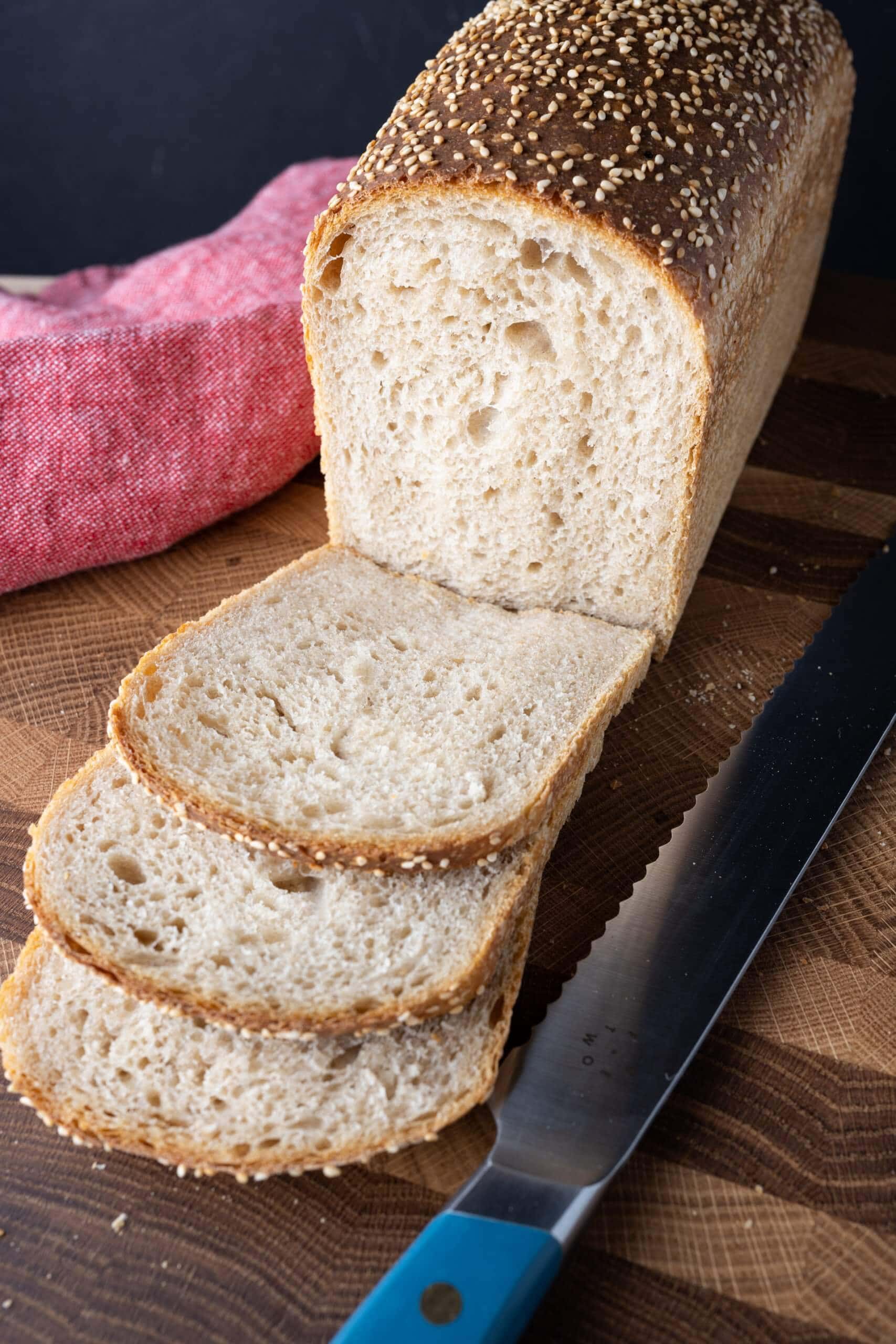 Sliced sourdough sandwich bread on cutting board