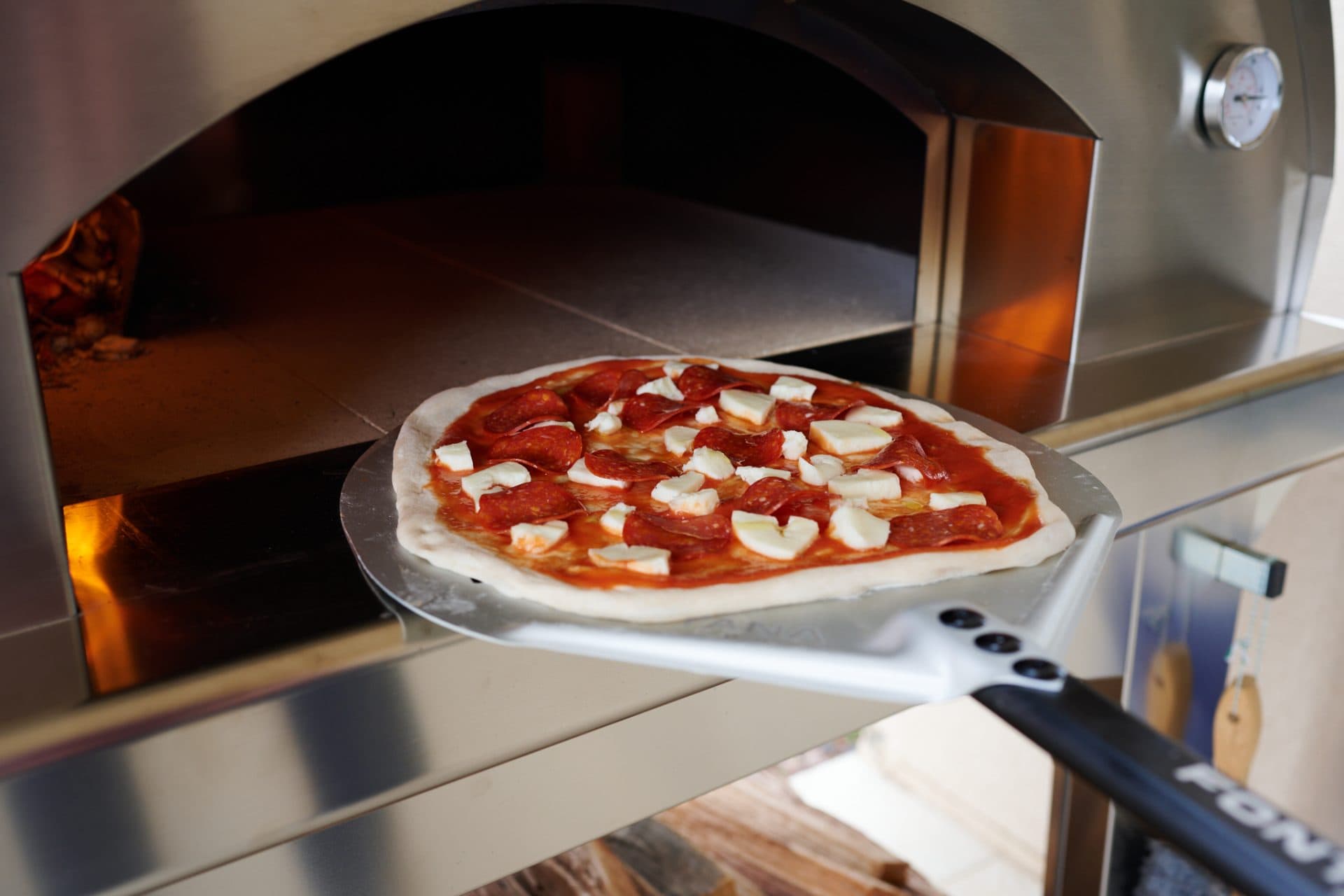 Sliding pizza in a wood-fired oven