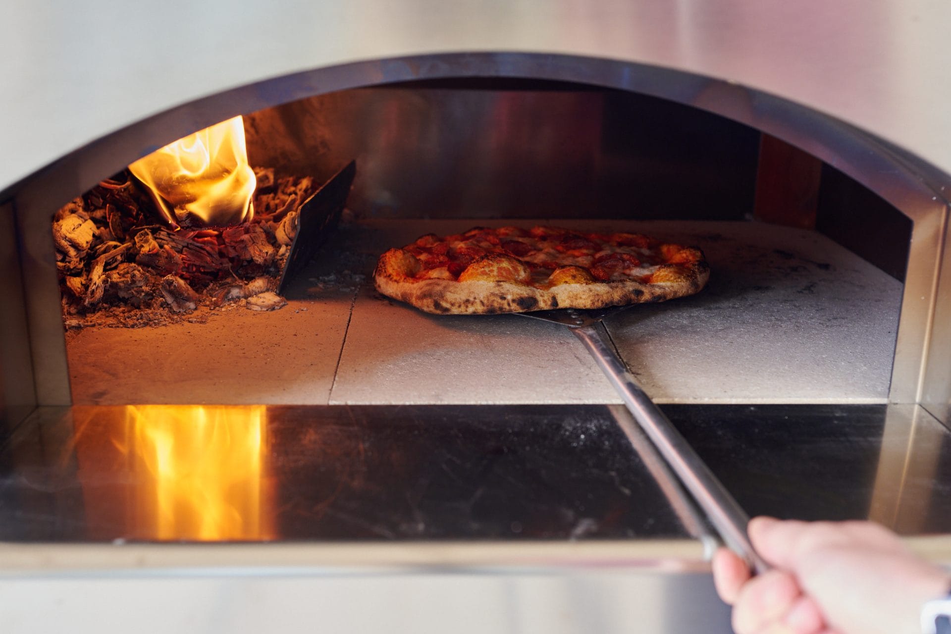 Cooking sourdough pizza in a wood-fired oven