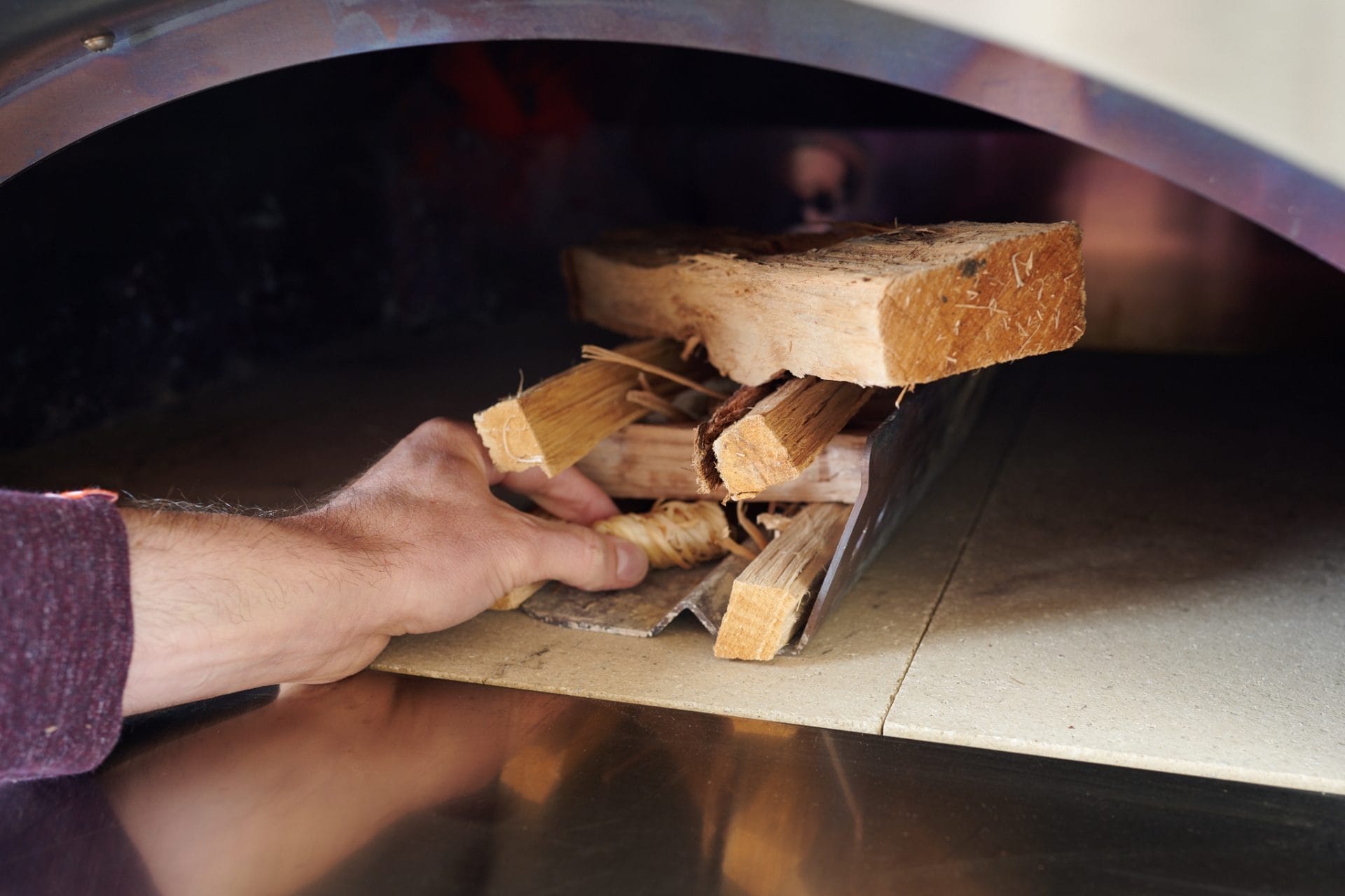 Creating a log cabin for lighting a wood-fired oven.