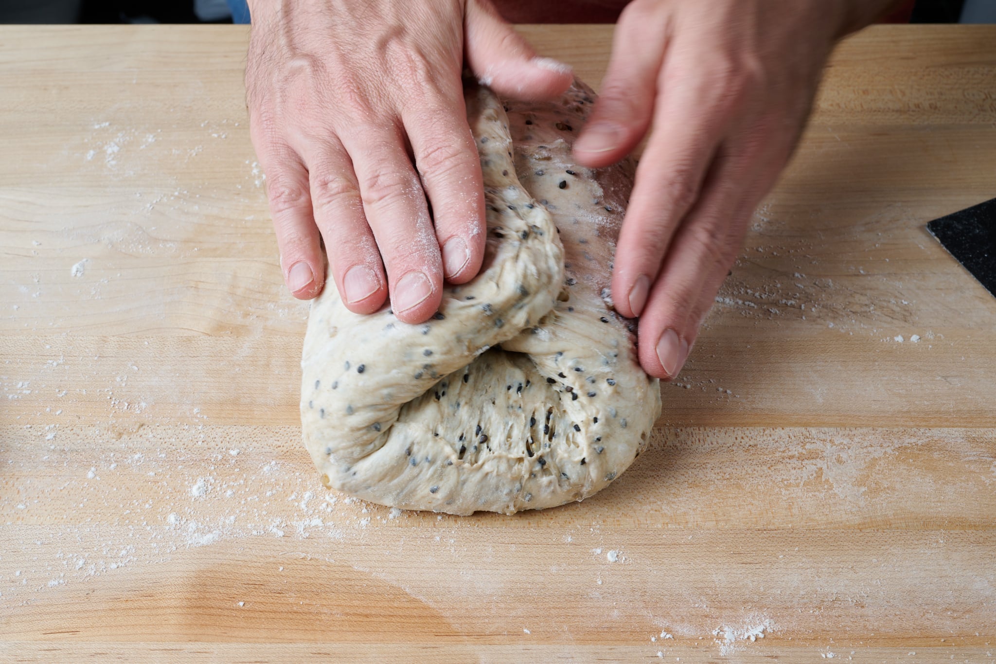 Shaping brown rice and sesame sourdough bread dough