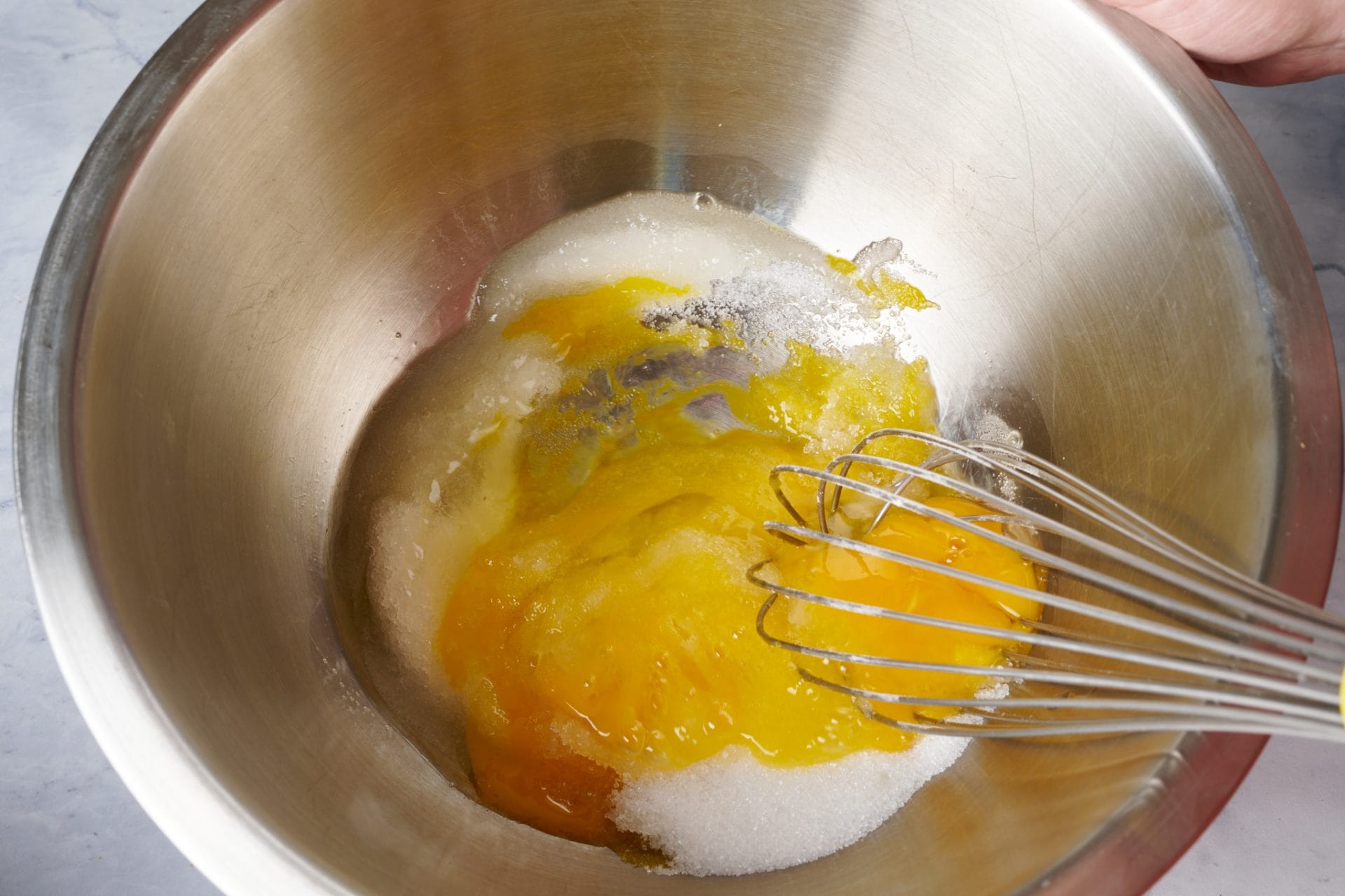 Sourdough starter discard cake step by step: Mixing egg and sugar.