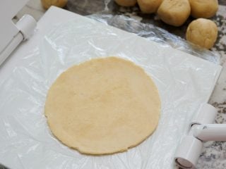 Pressing sourdough tortilla dough out with a Masienda press.