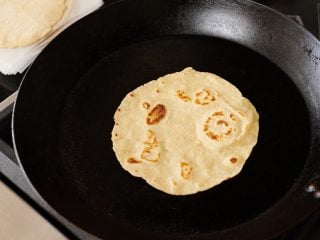 Cooking sourdough tortillas on a hot carbon steel pan.