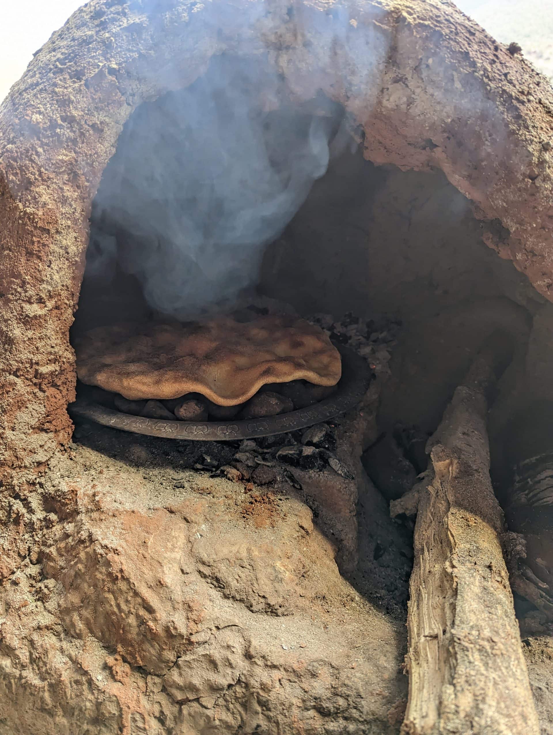 The Breads of Morocco: Tafarnoute baking on top of stones.