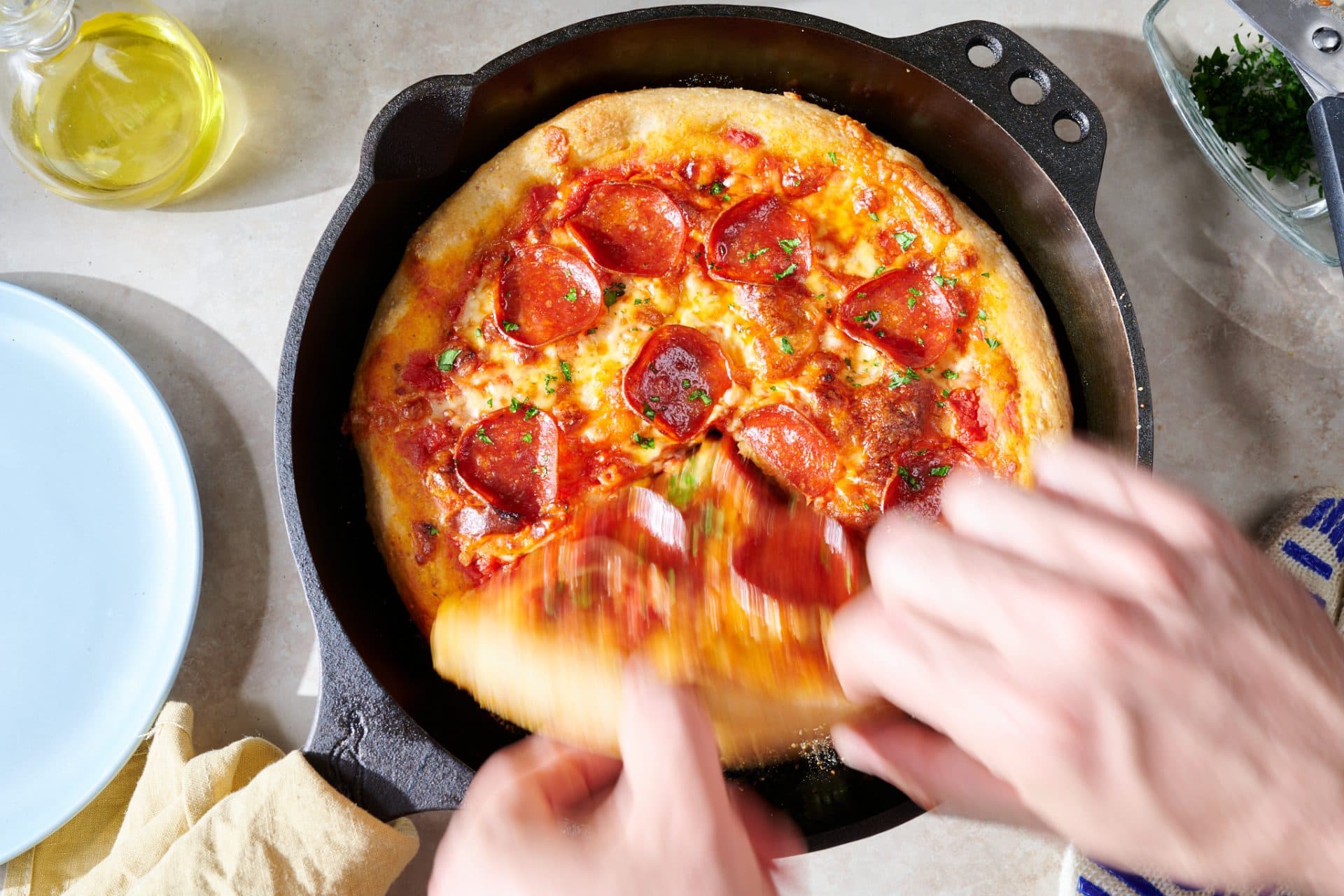 Taking a slice of the cornmeal skillet sourdough pizza.