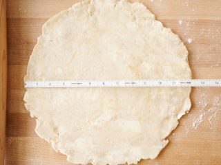 Rolling sourdough pie crust out to 12 inches.