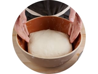 Dough during bulk fermentation showing smooth surface and elasticity.