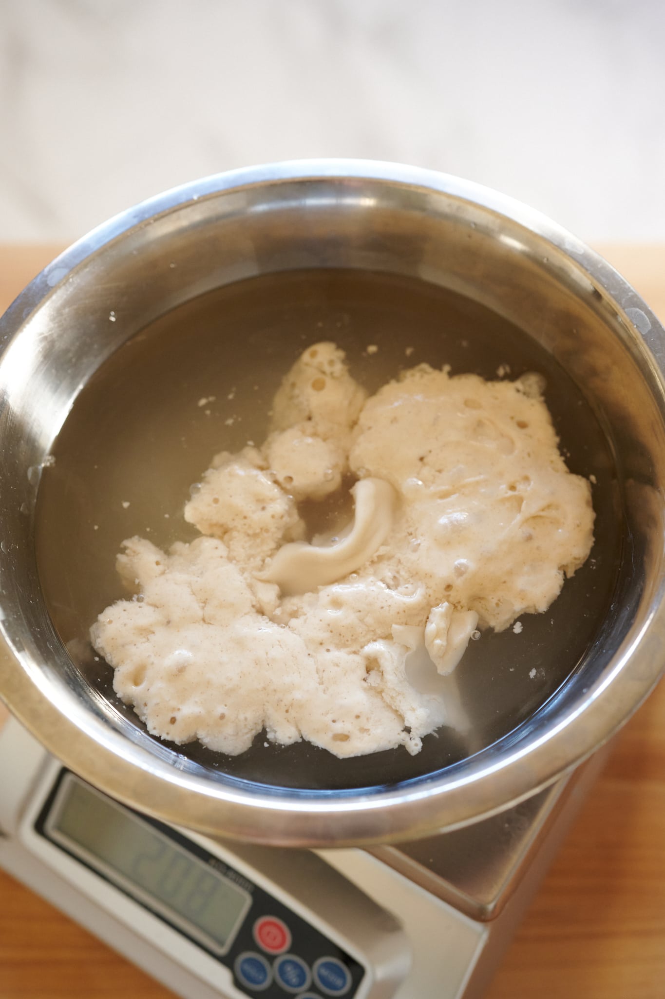 Adding sourdough starter into mixing water.