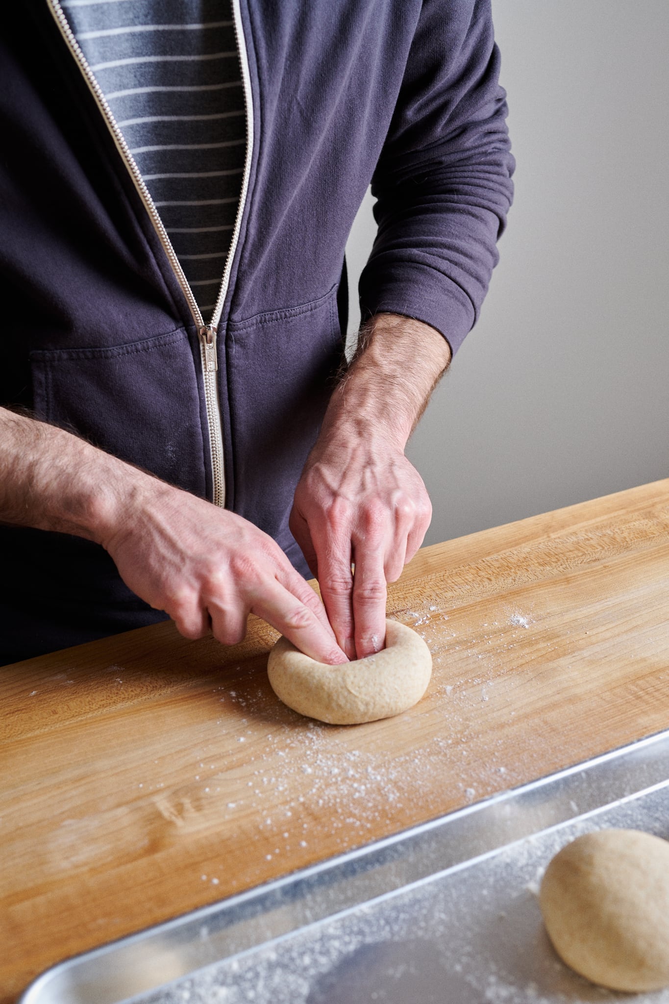 Punching a hole in the sourdough friselle dough to make a ring.