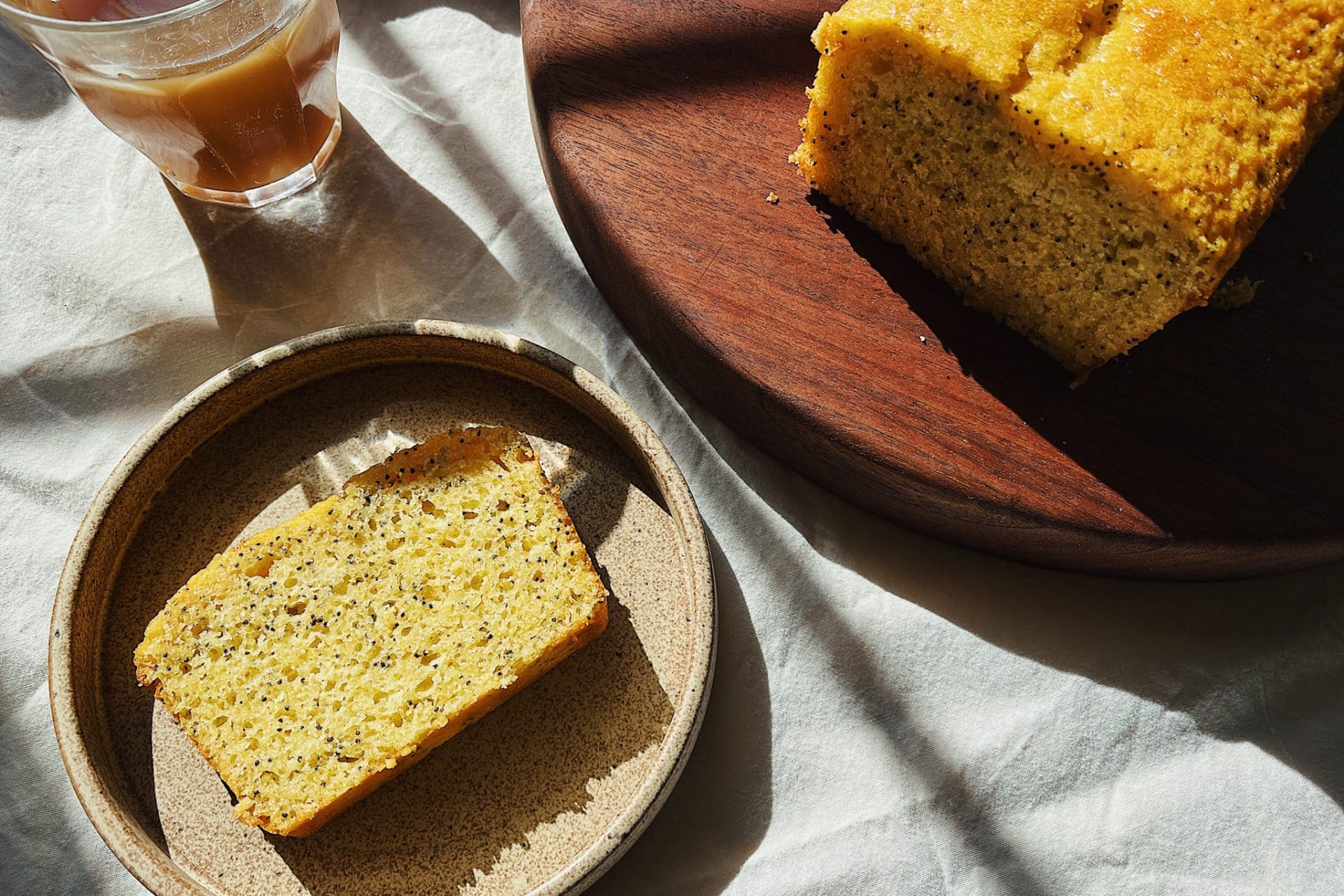 Lemon poppyseed loaf sliced on plate showing super soft crumb.