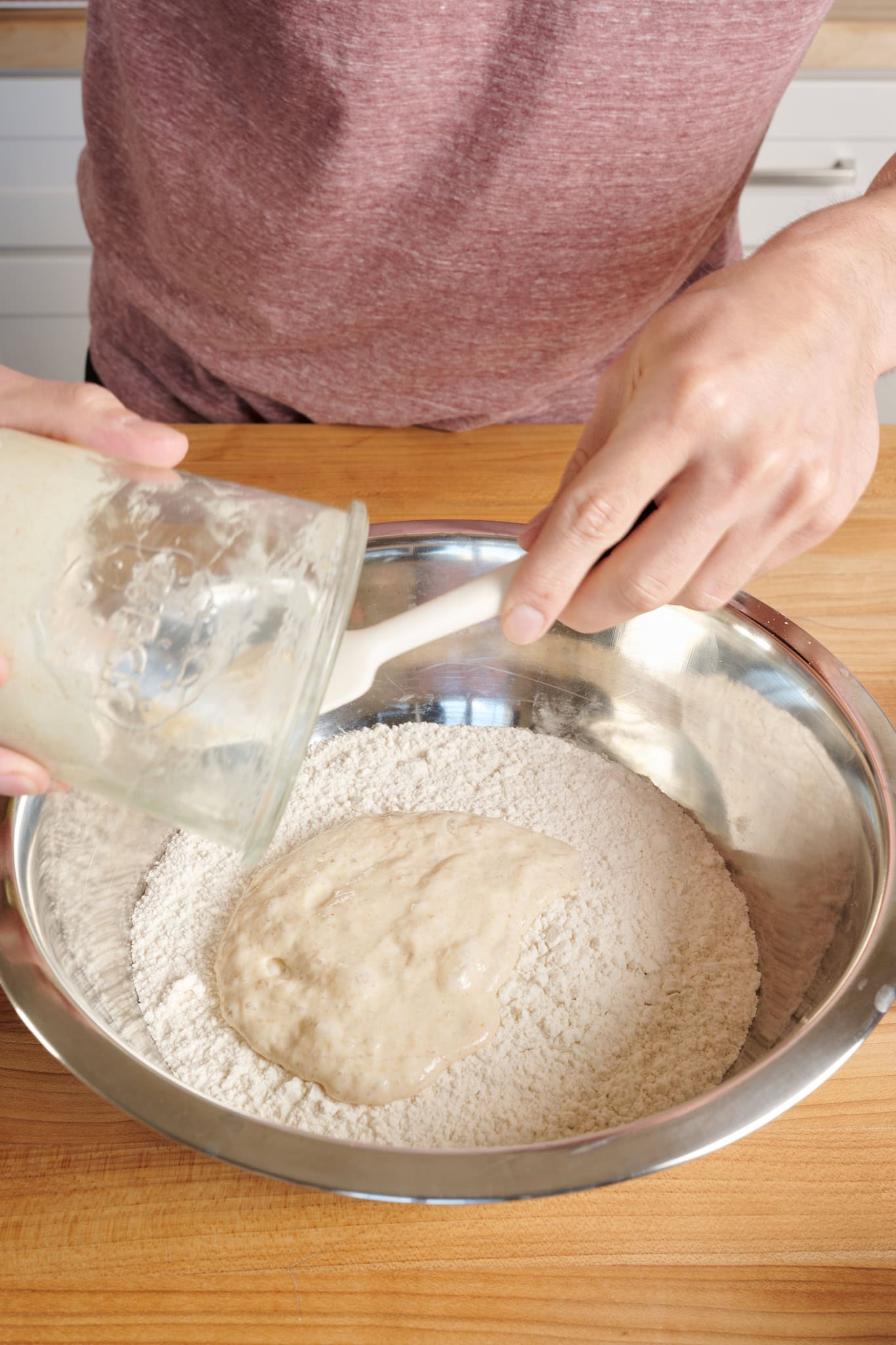Adding ripe sourdough starter to flour for mixing