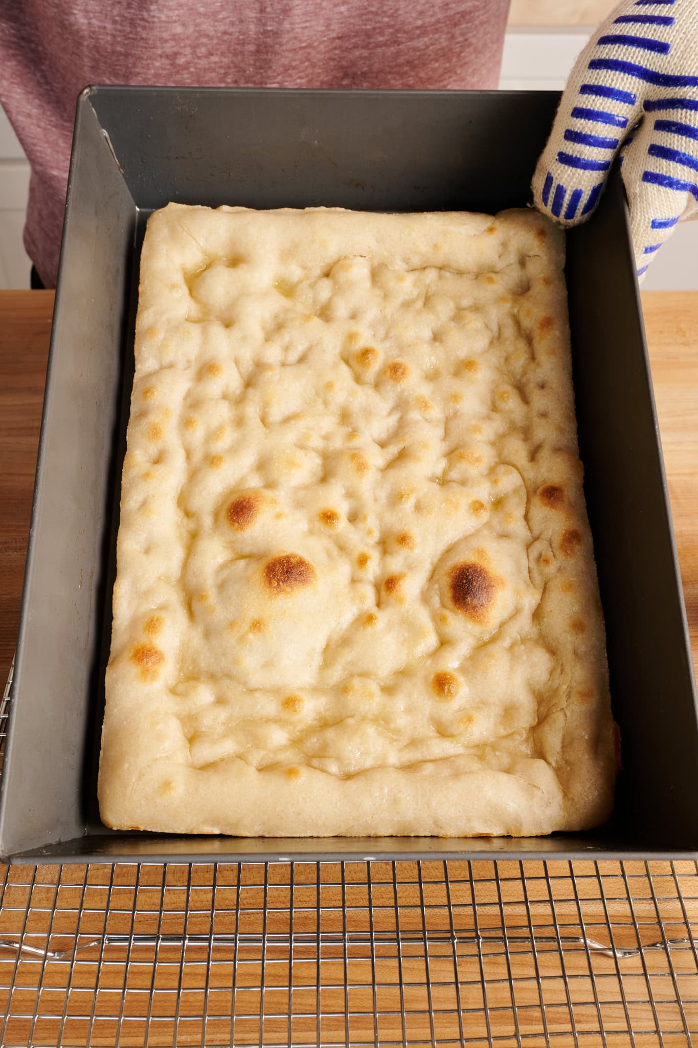 The top of the parbaked Detroit-style pizza dough.