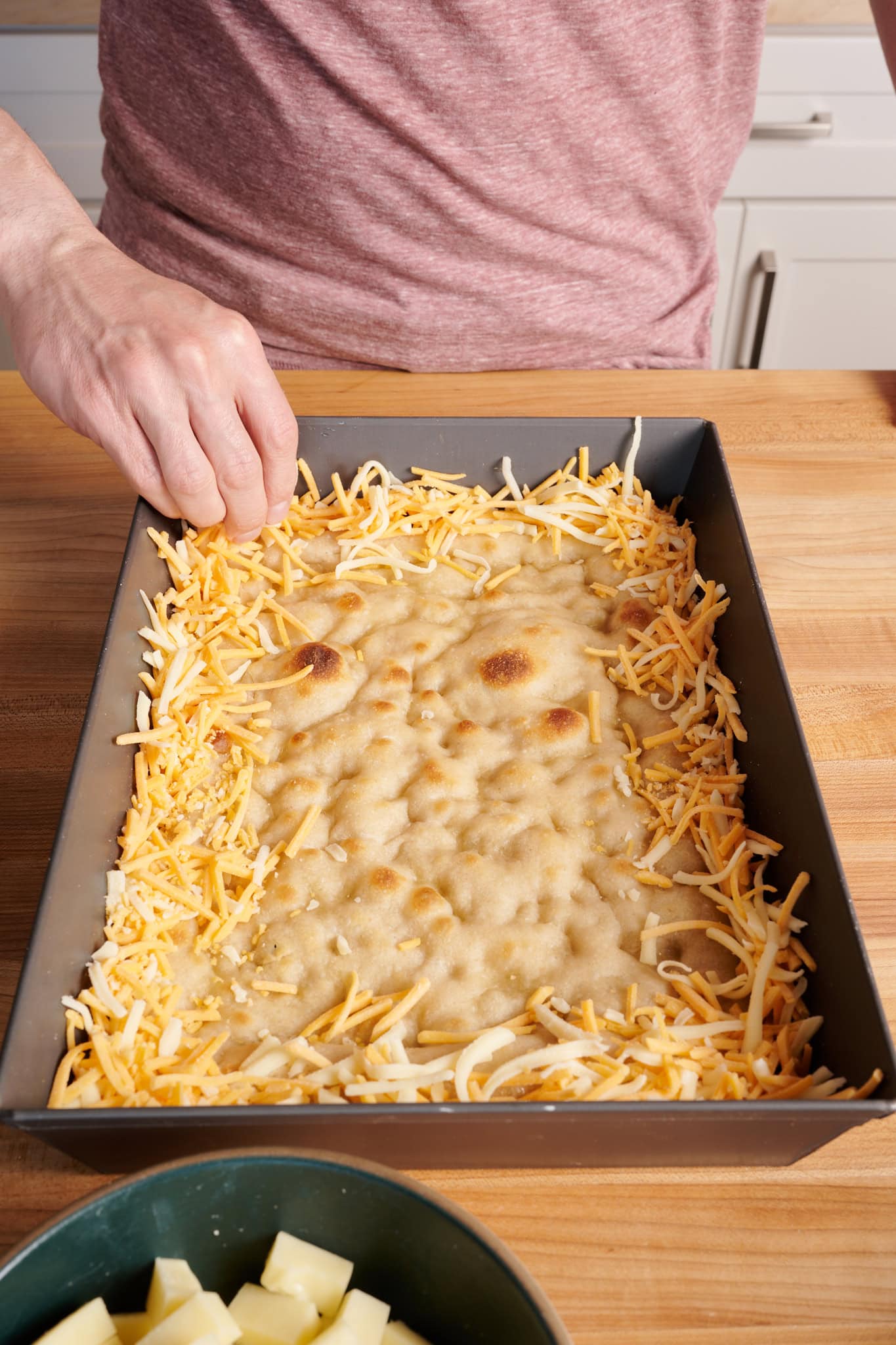 Creating the frico crust on a Detroit-style pizza.