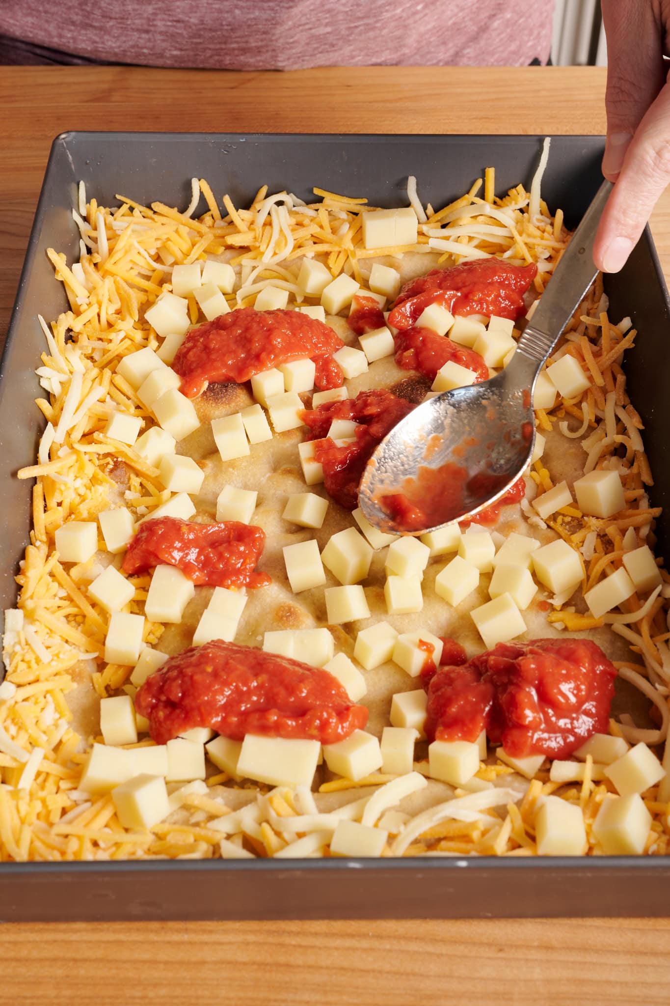 Spread the tomato sauce evenly over the cheese.
