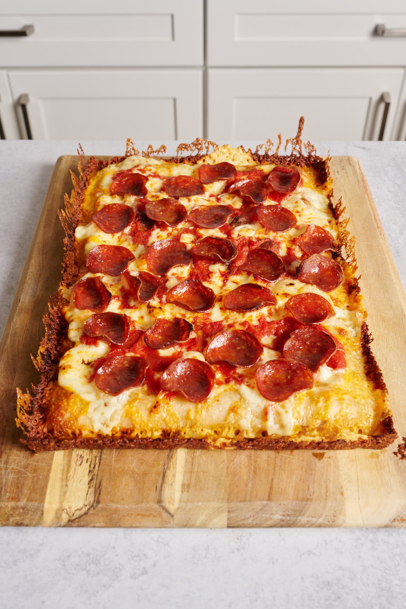 Finished Detroit-style pizza with cheese frico crust.