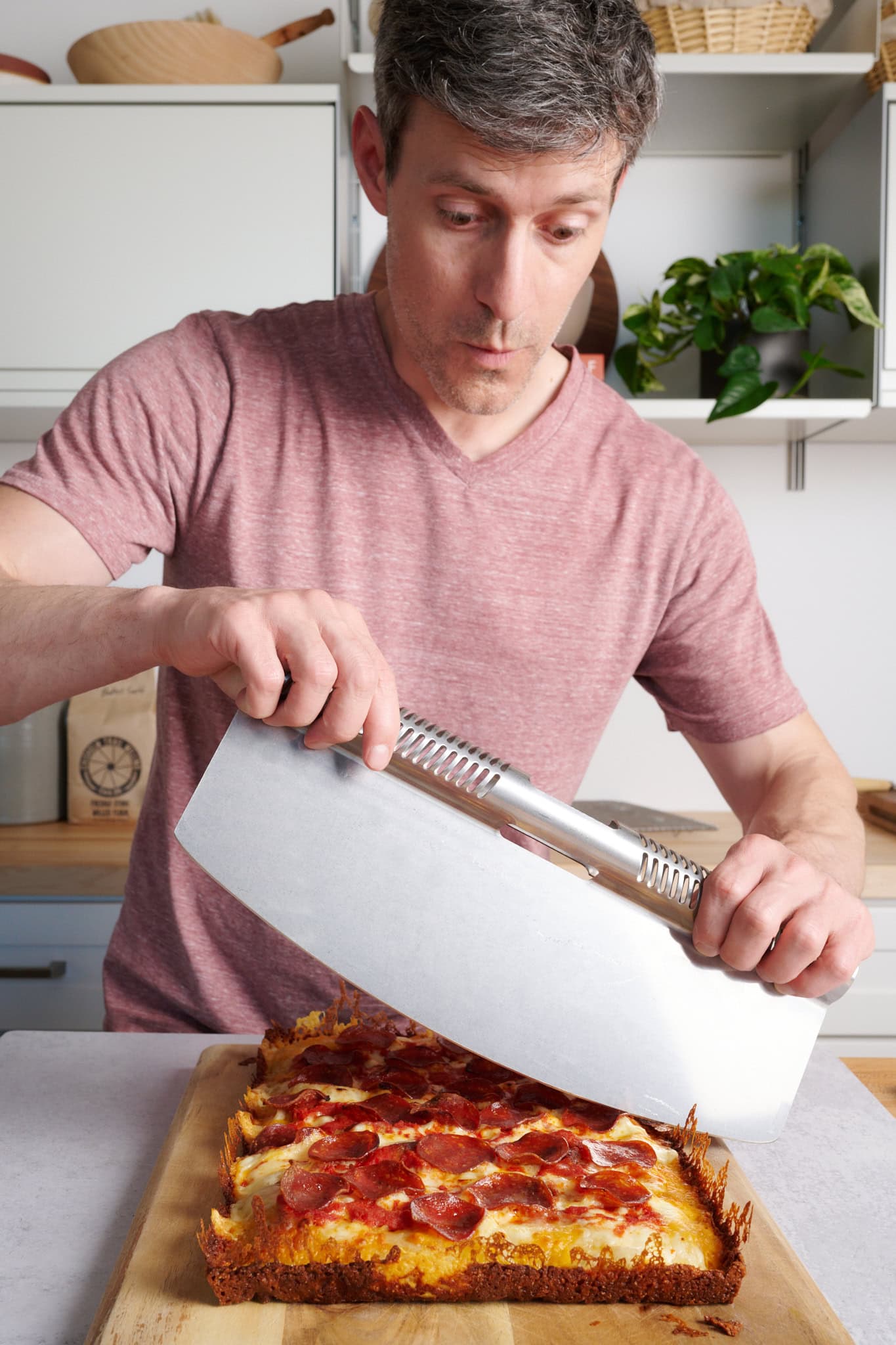 Maurizio Leo cutting into a Detroit-style pizza