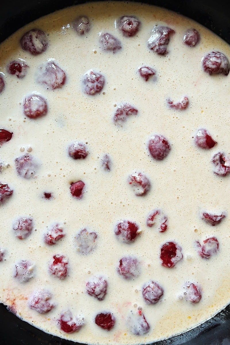 Naturally leavened waste clafoutis with cherries and cream just before baking.
