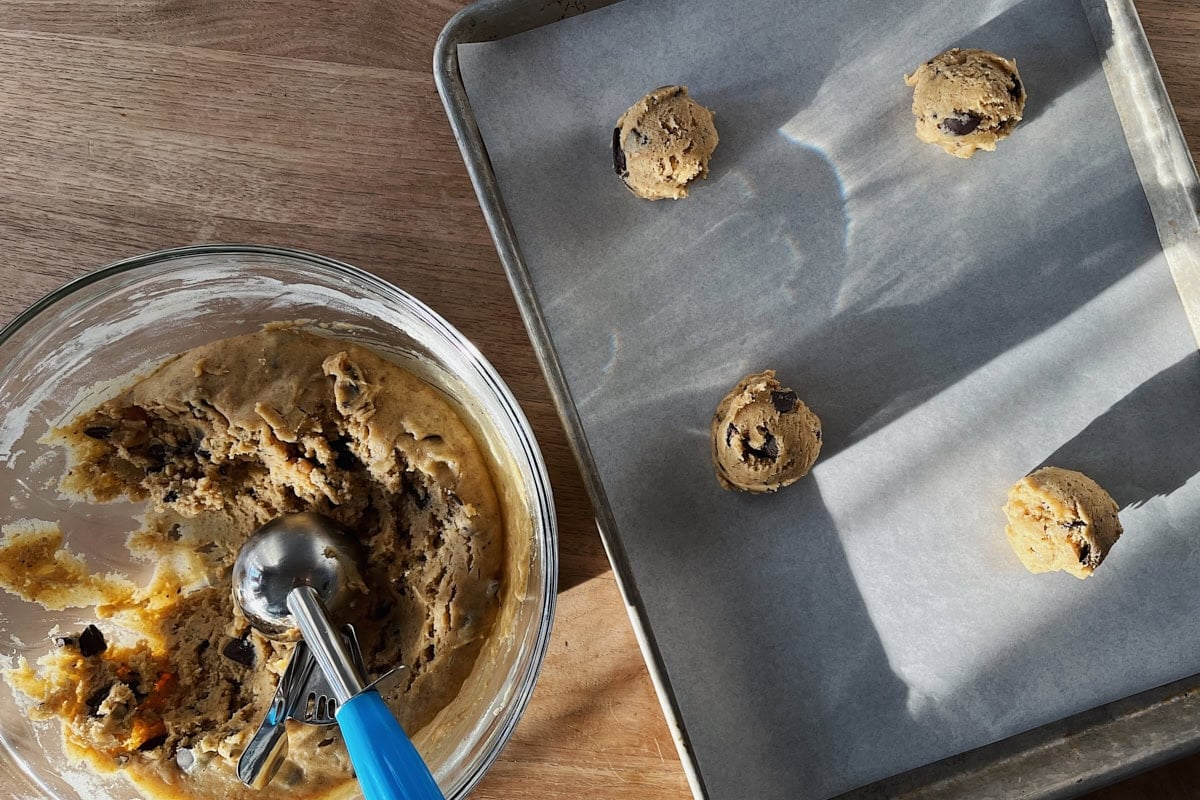 Scooping sourdough starter discard chocolate chip cookie dough for baking.