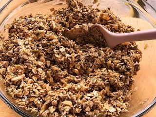 Adding sourdough starter discard to granola mixture.