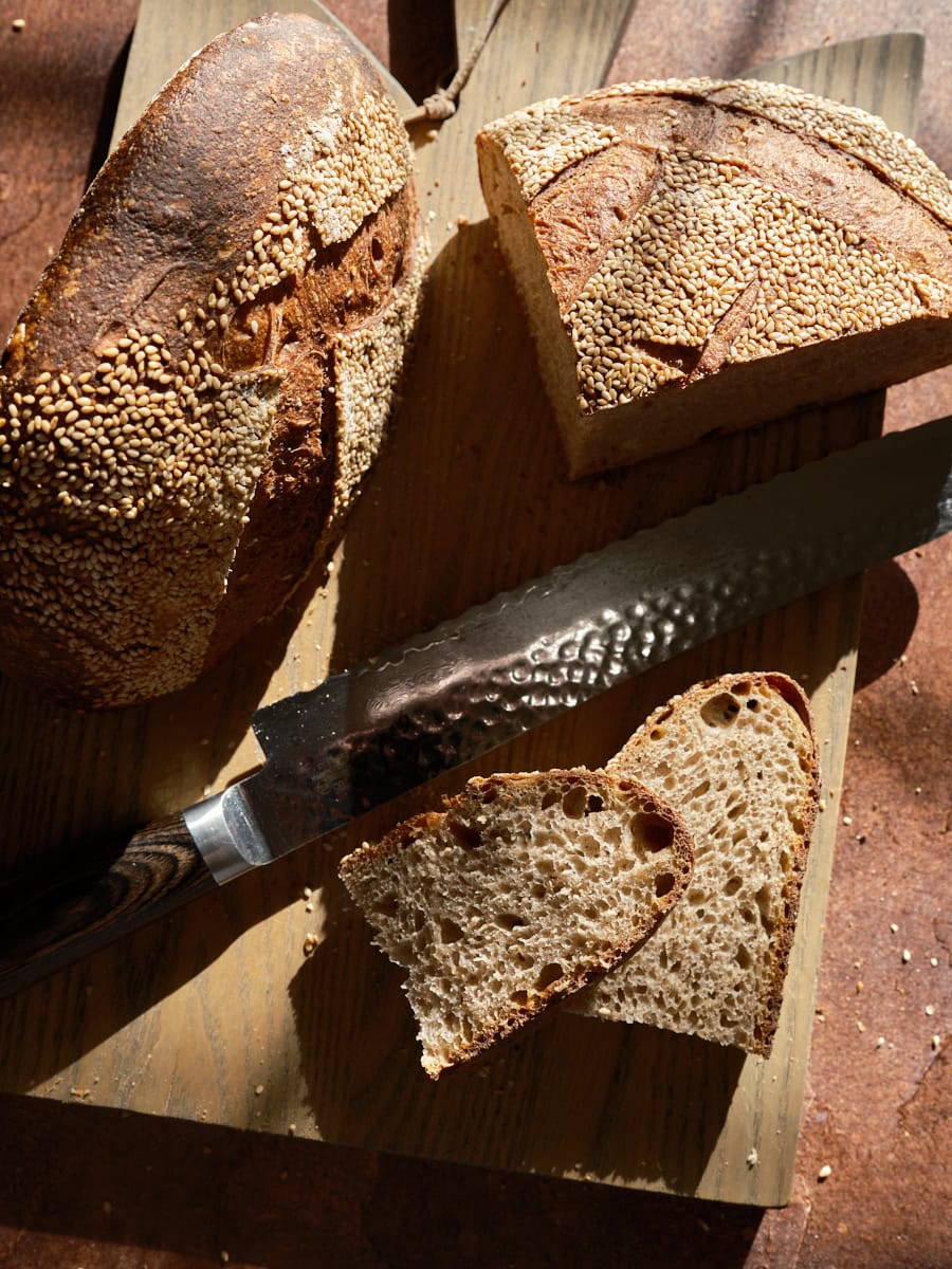 Scalded buckwheat and malt sourdough bread sliced on cutting board.