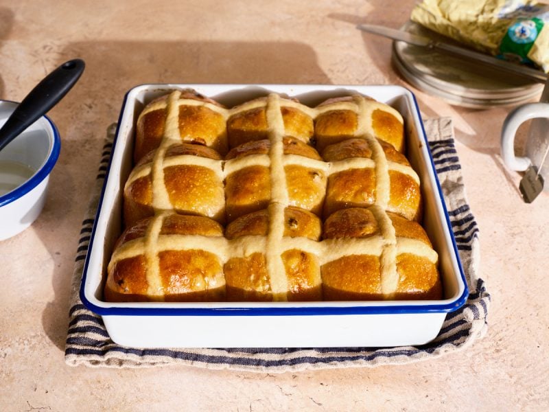 Sourdough hot cross buns baked and in a pan.
